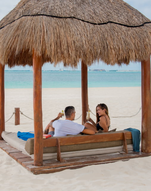 Clients of Playa Norte Beach Club enjoying the service in the palapa