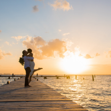 Novios besándose frente a la costa de Isla Mujeres