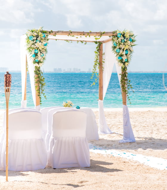 Arco, mesas y sillas de boda en la playa