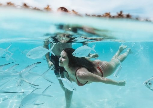 Cliente sumergiéndose en las cristalinas aguas del mar caribe