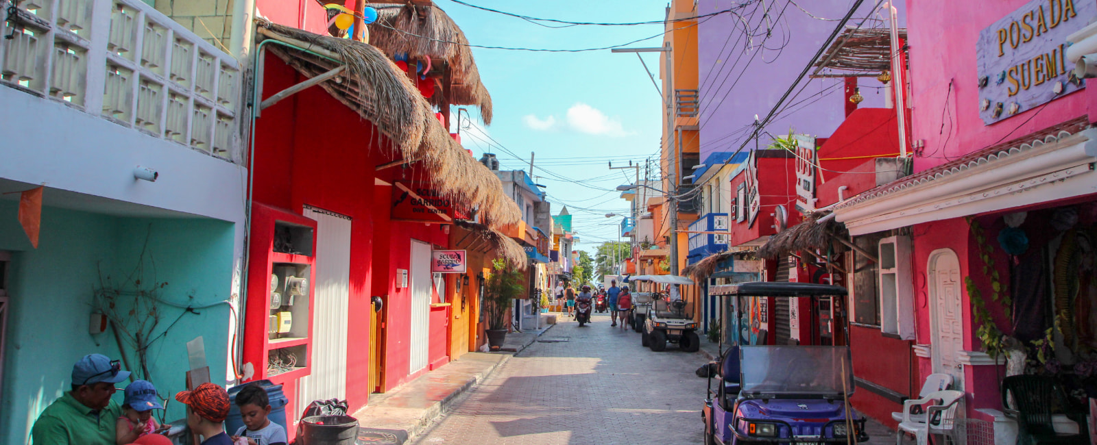 View of a street with colorful shops and houses in Isla Mujeres.