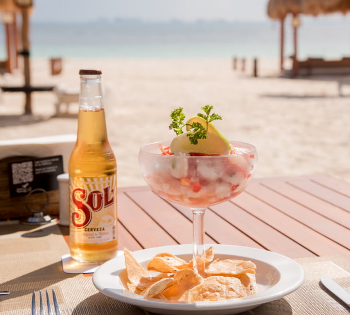 Beer and starter at a table on the sand