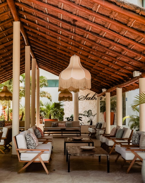 Covered terrace with tables and chairs at the Sabor restaurant.