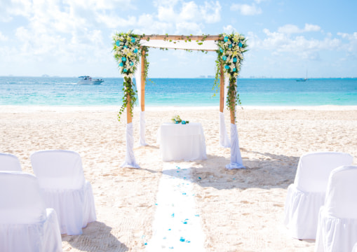 Arch of flowers, altar and chairs in the sand