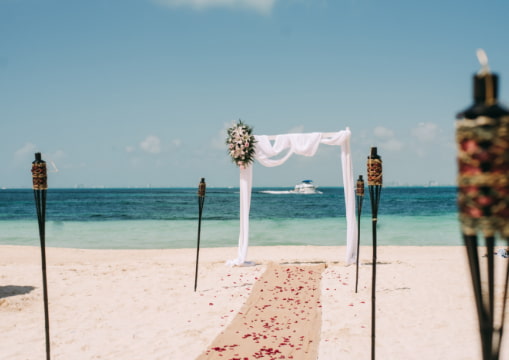 Arch of flowers, altar and chairs in the sand