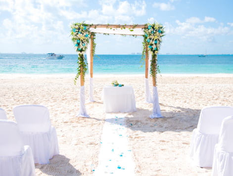 Altar, pasillo y sillas en la arena de la boda