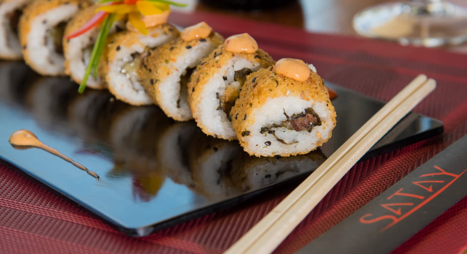 Pieces of sushi served in a black dish