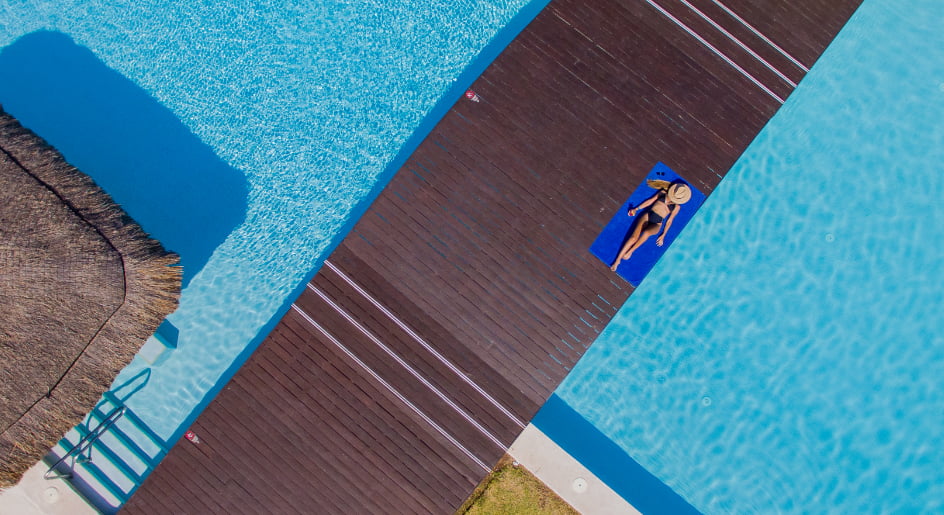 Woman relaxing at the swimming pool with a bridge