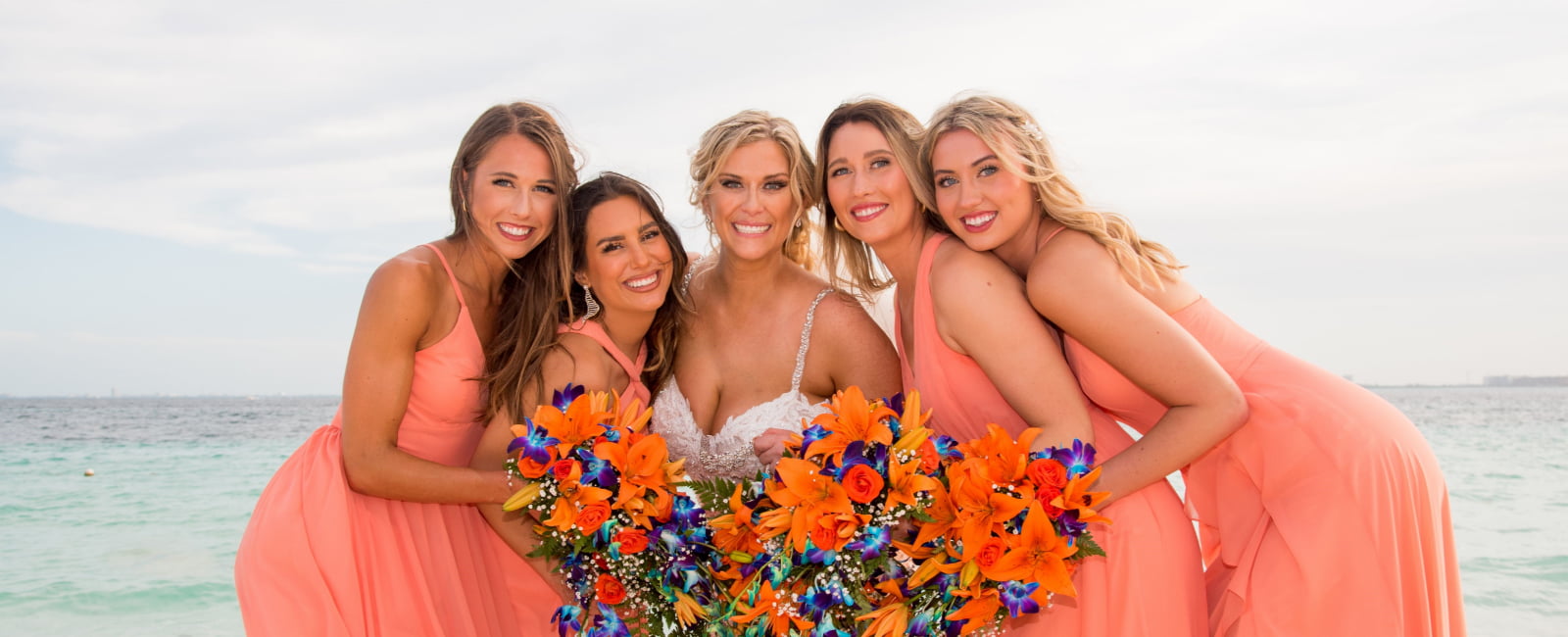 Bride and bridesmaids elegantly dressed for wedding posing in the photo.